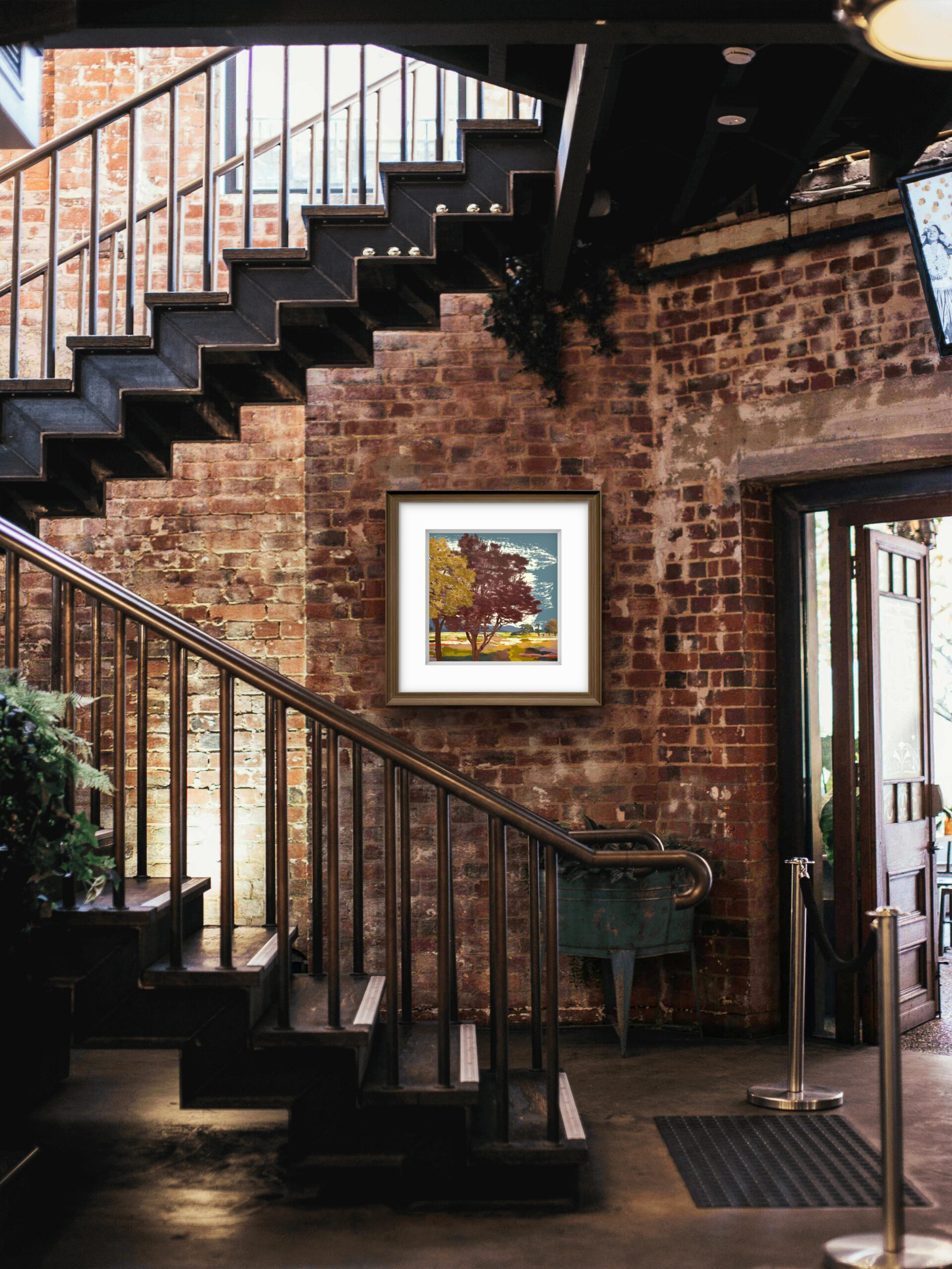 Shadow Trees framed limited edition print displayed against an exposed brick wall