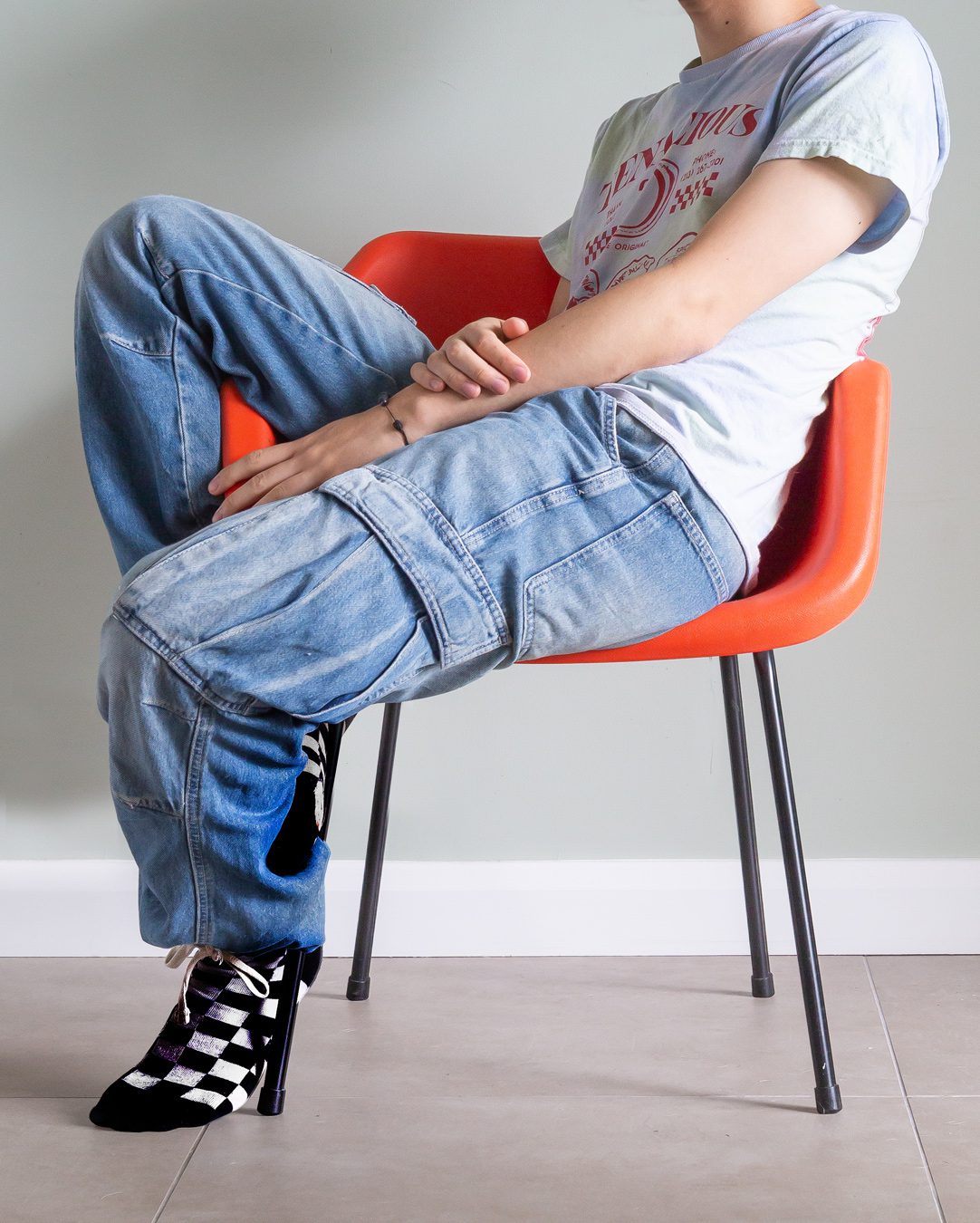Cropped image of a man sitting on an orange chair. Portraits for shy people