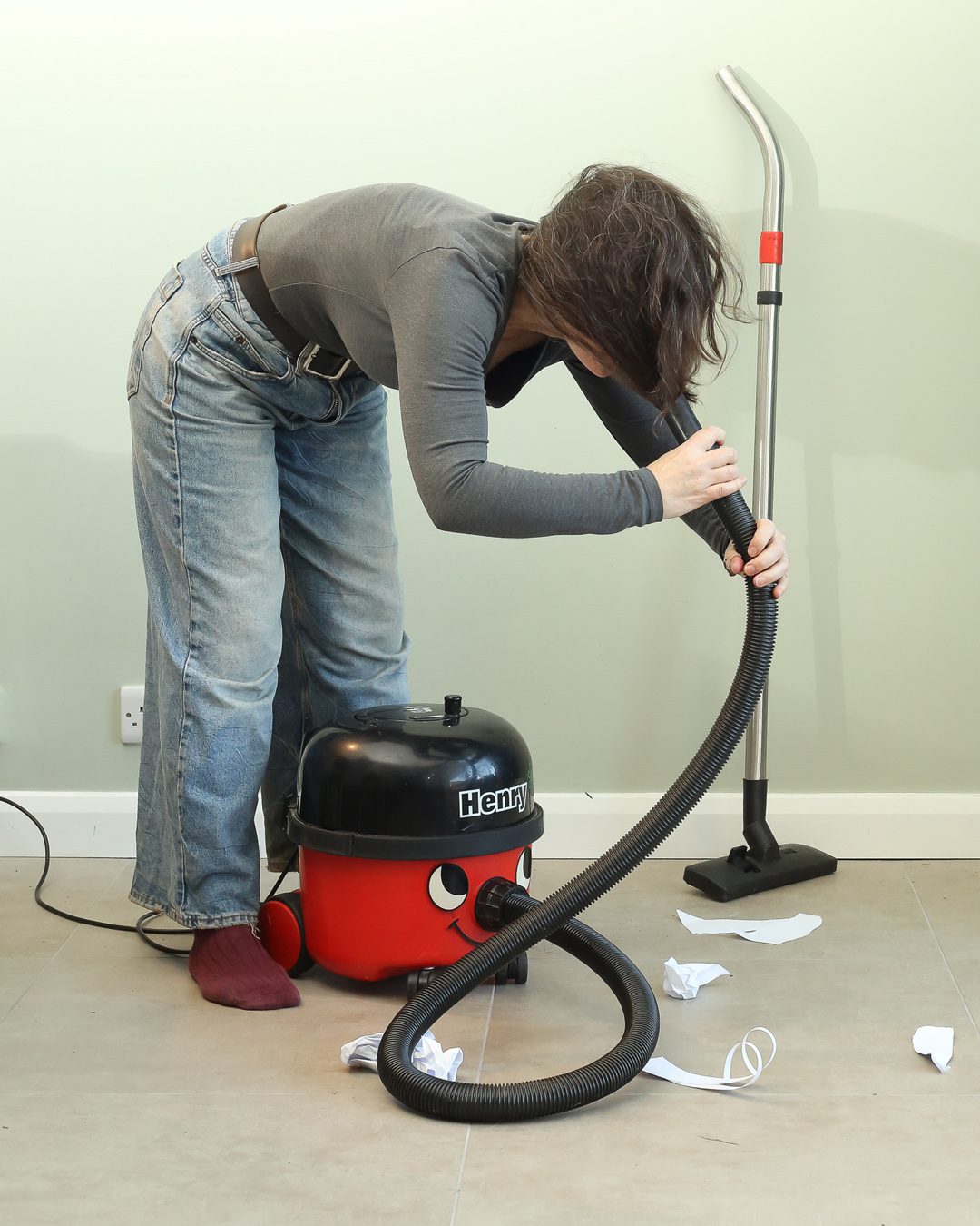 Woman with henry hoover. her hair is being sucked up by the hoover. Portraits for shy people